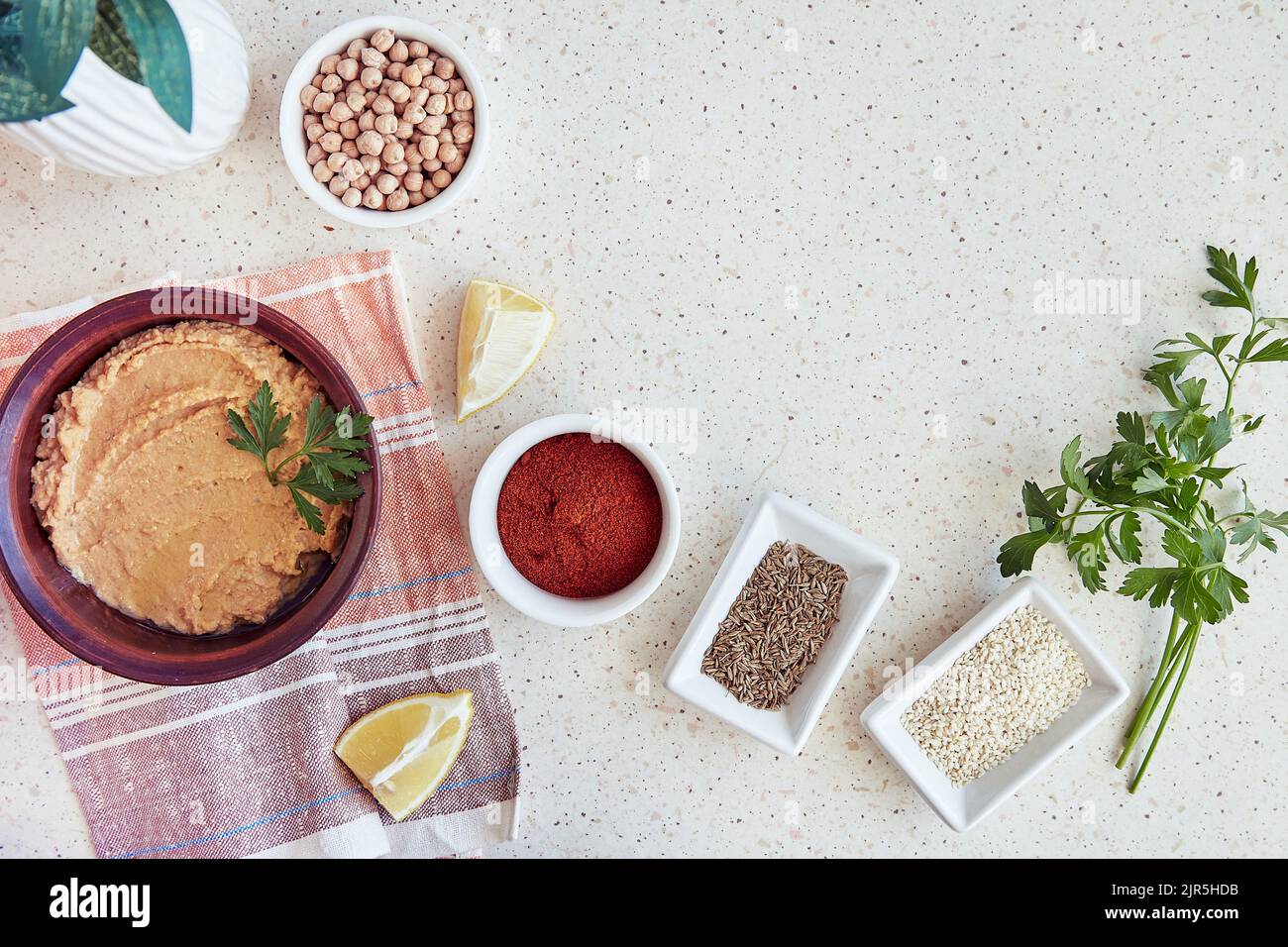 Hummus with chickpeas and tahini sause in the bowl parsley, lemon