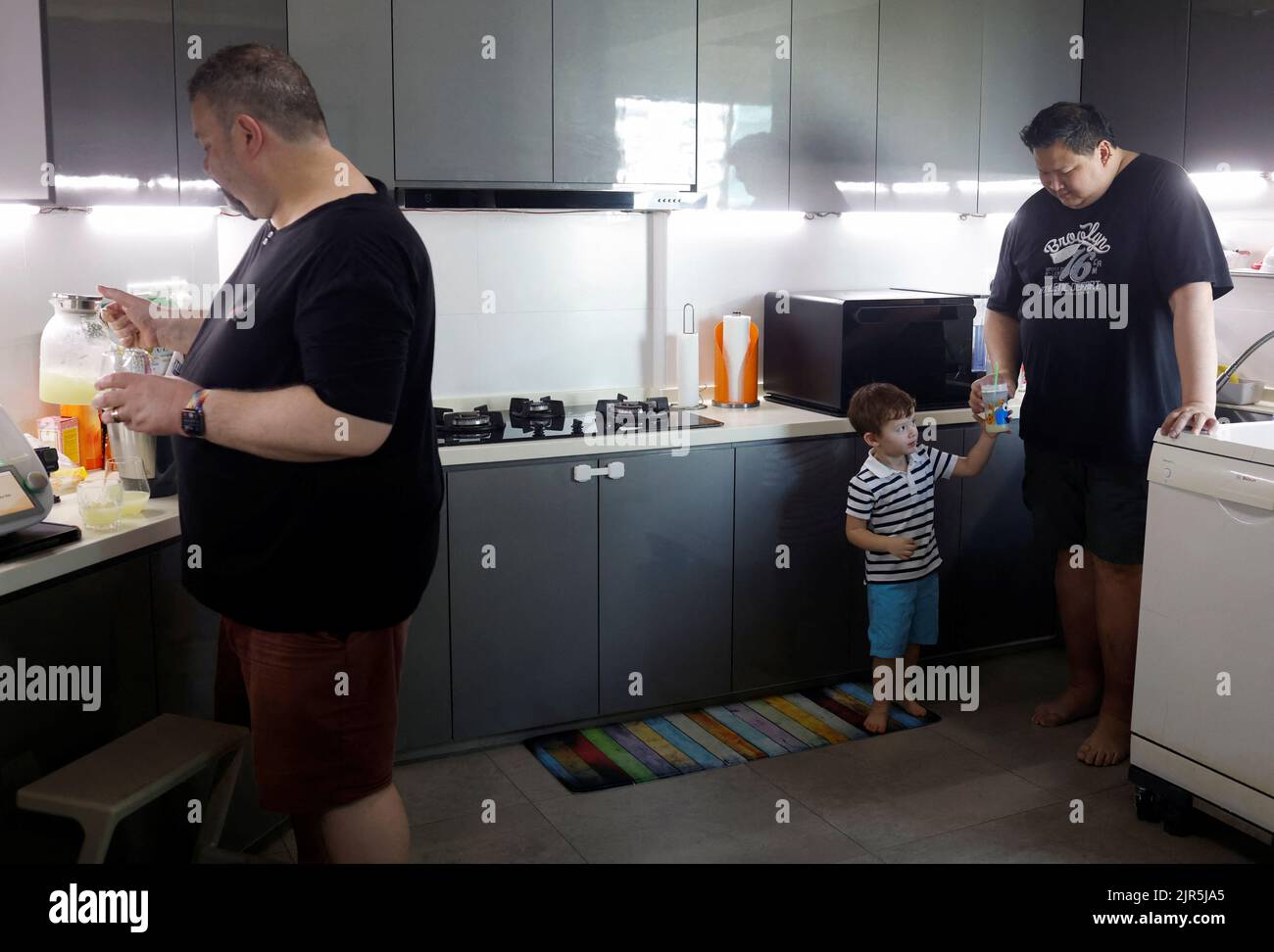 Same-sex parents Andre Ling, 44, and Cameron Sutherland, 47, make lemonade with their two year old son Tyler at home in Singapore August 22, 2022. REUTERS/Edgar Su Stock Photo