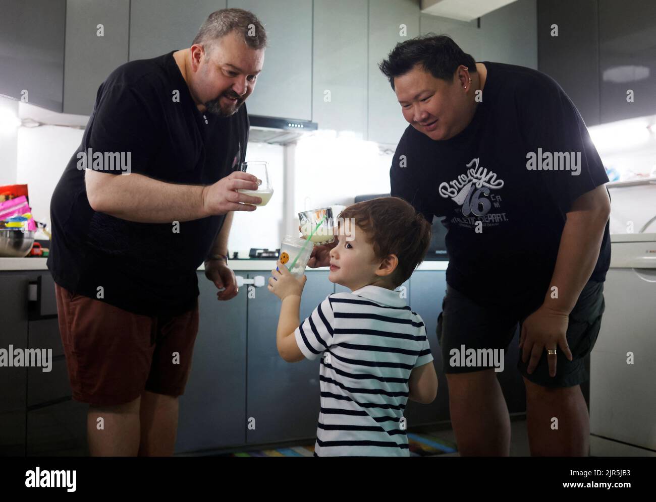 Same-sex parents Andre Ling, 44, and Cameron Sutherland, 47, make lemonade with their two year old son Tyler at home in Singapore, August 22, 2022. REUTERS/Edgar Su Stock Photo