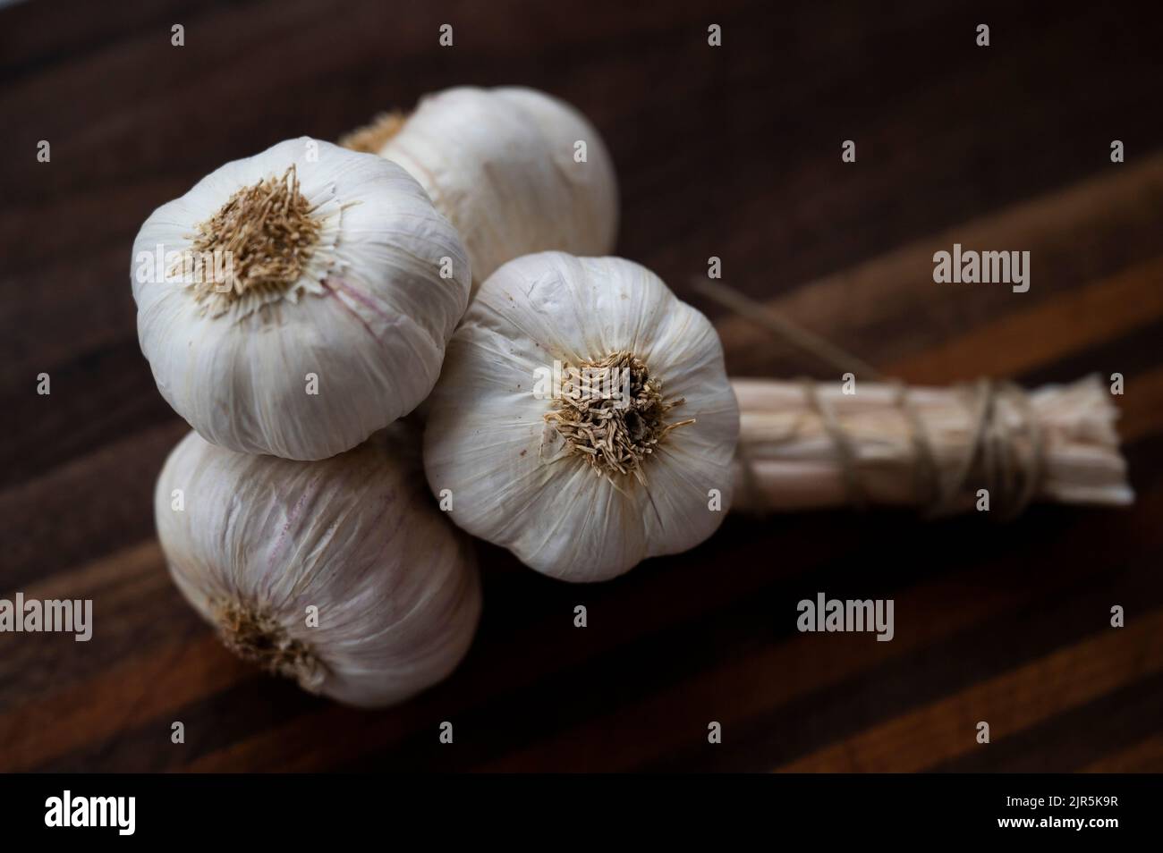A bunch of garlic cloves on a chopping board Stock Photo - Alamy