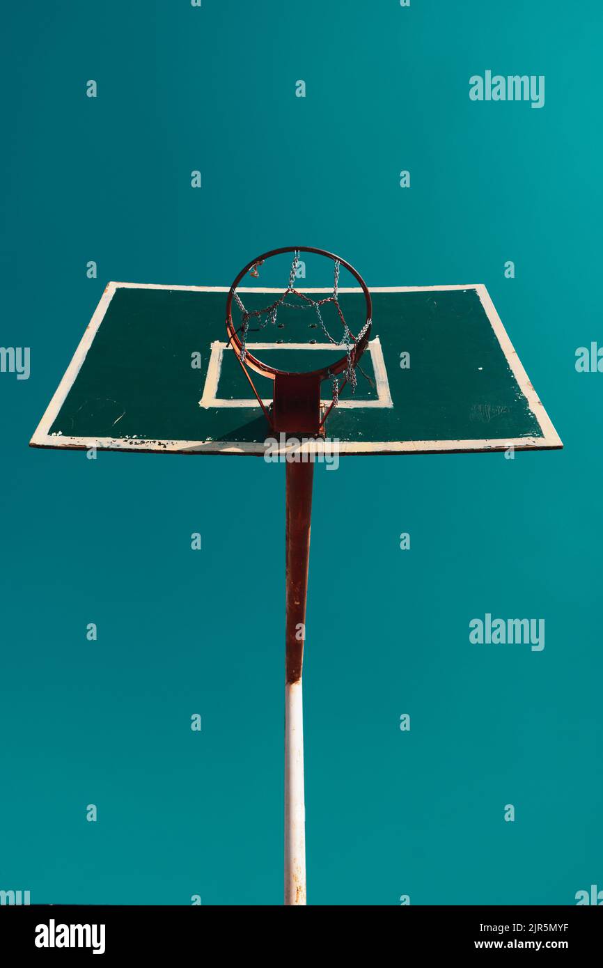 Basketball hoop shot from the bottom showing the clear skies behind it