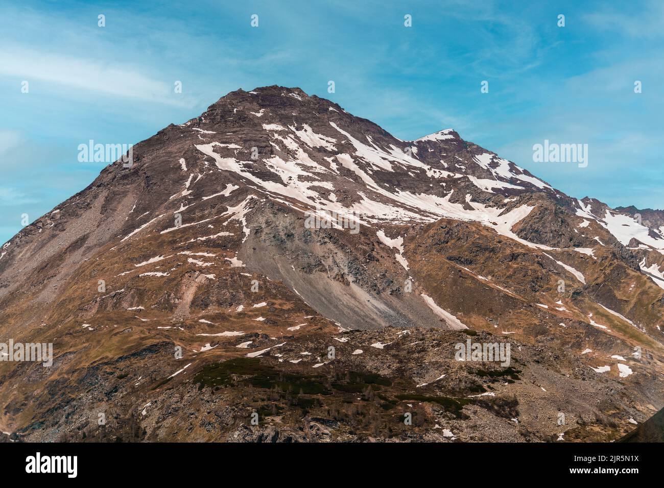 High mountain in the alps, austria, partly covered with snow, with a