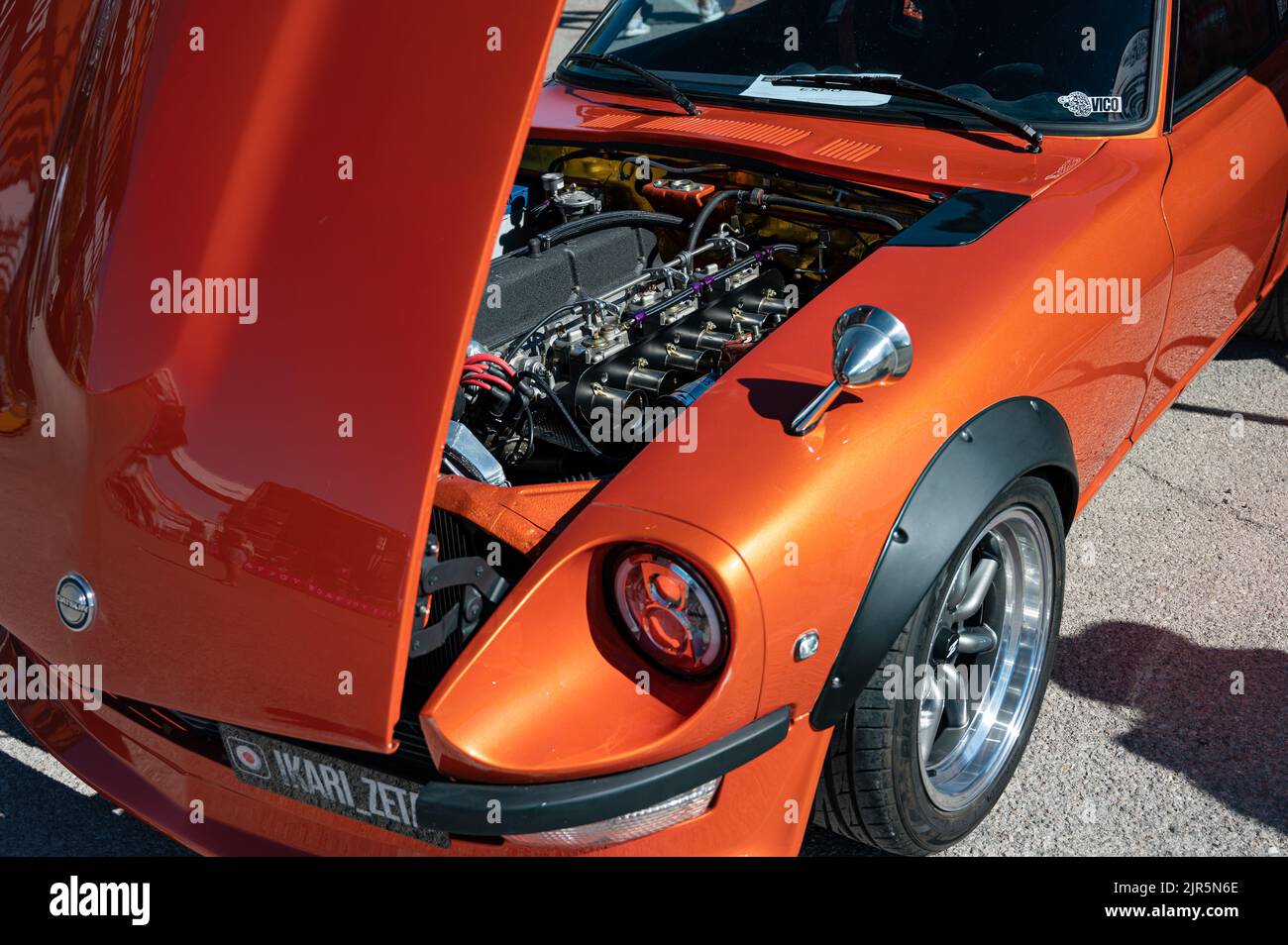 The details on the inside of a classic orange Japanese Datsun 240z parked at an exhibition Stock Photo