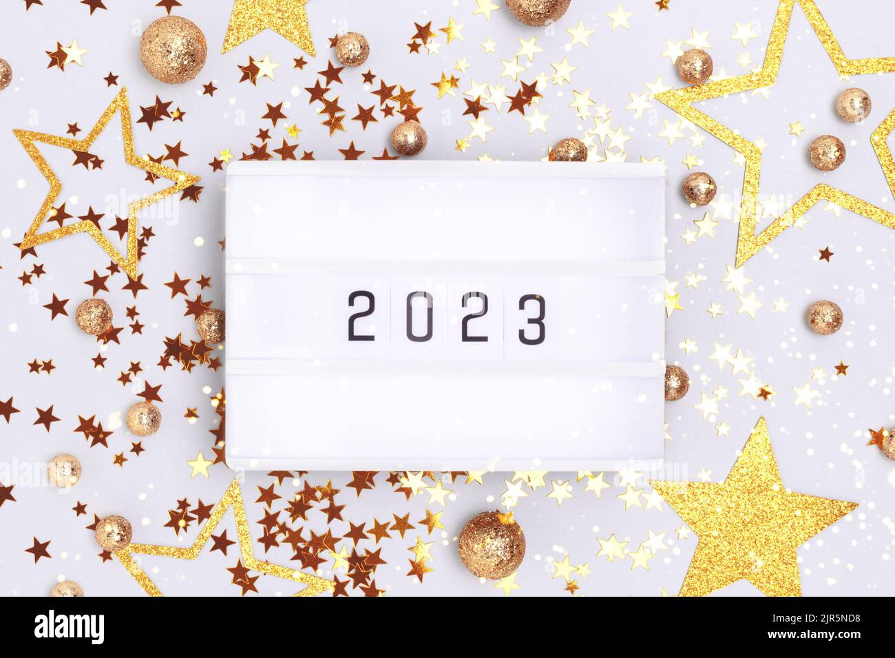New 2023 Year concept. Lightbox and golden glittering confetti on a blue background. Stock Photo