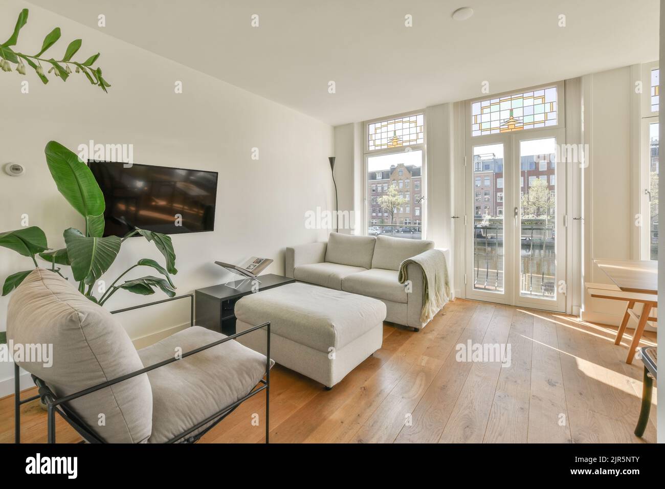 Contemporary open plan kitchen with dining table set and gray sofa in
