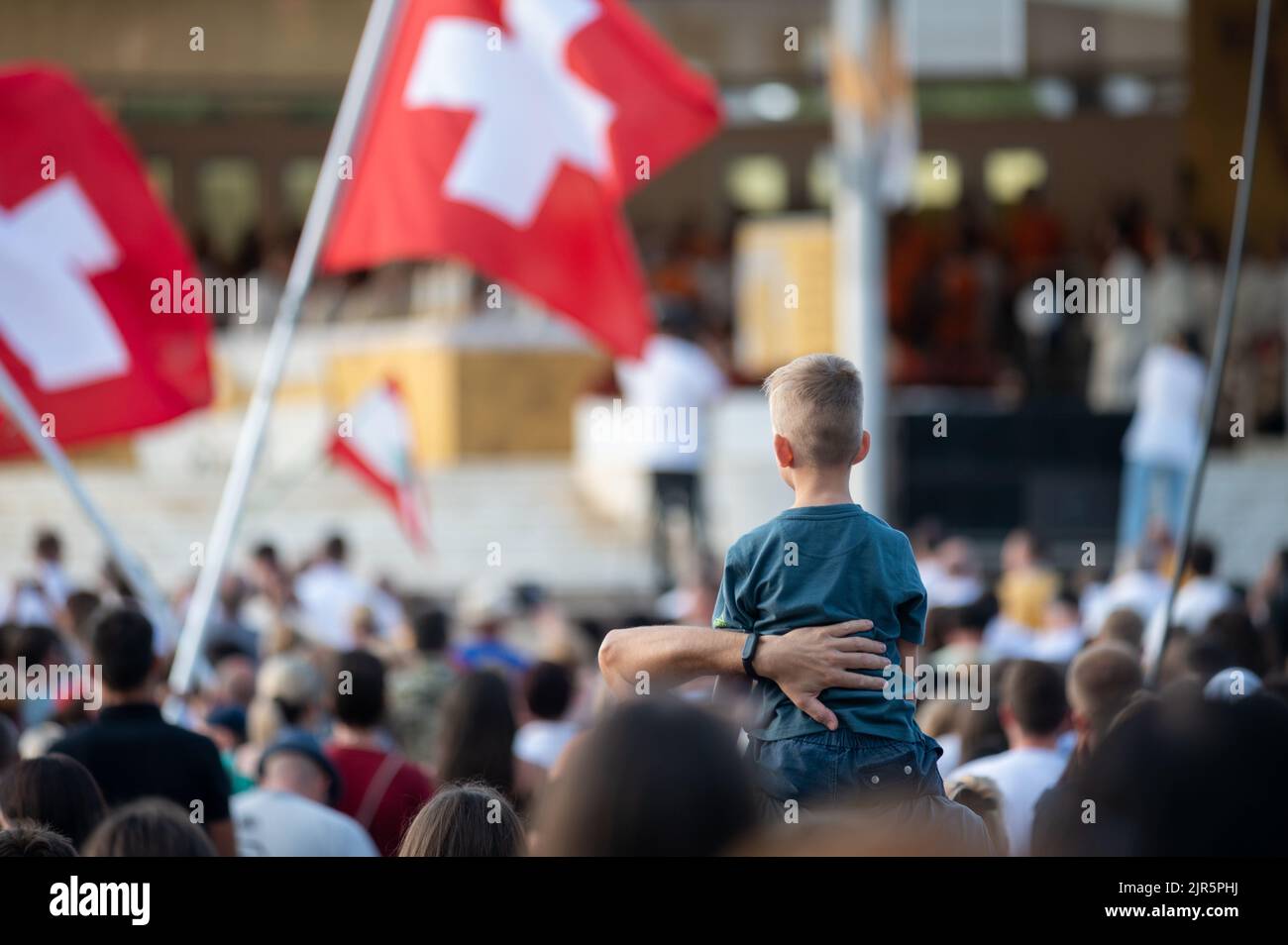 A little boy on father's shoulders in a crowd of people. Holy Mass during Mladifest 2021 in Medjugorje. Stock Photo