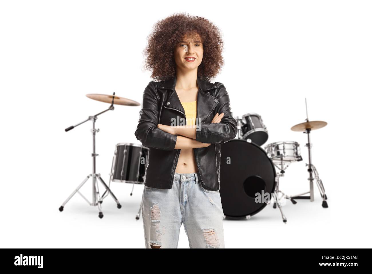 Young woman with afro hairstyle wearing a leather jacket and standing on front of drums isolated on white background Stock Photo