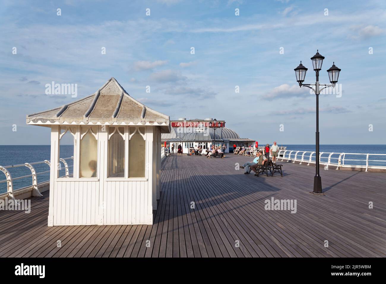 On Cromer Pier with shelter and lamp with the Pavilion theatre in the background Stock Photo
