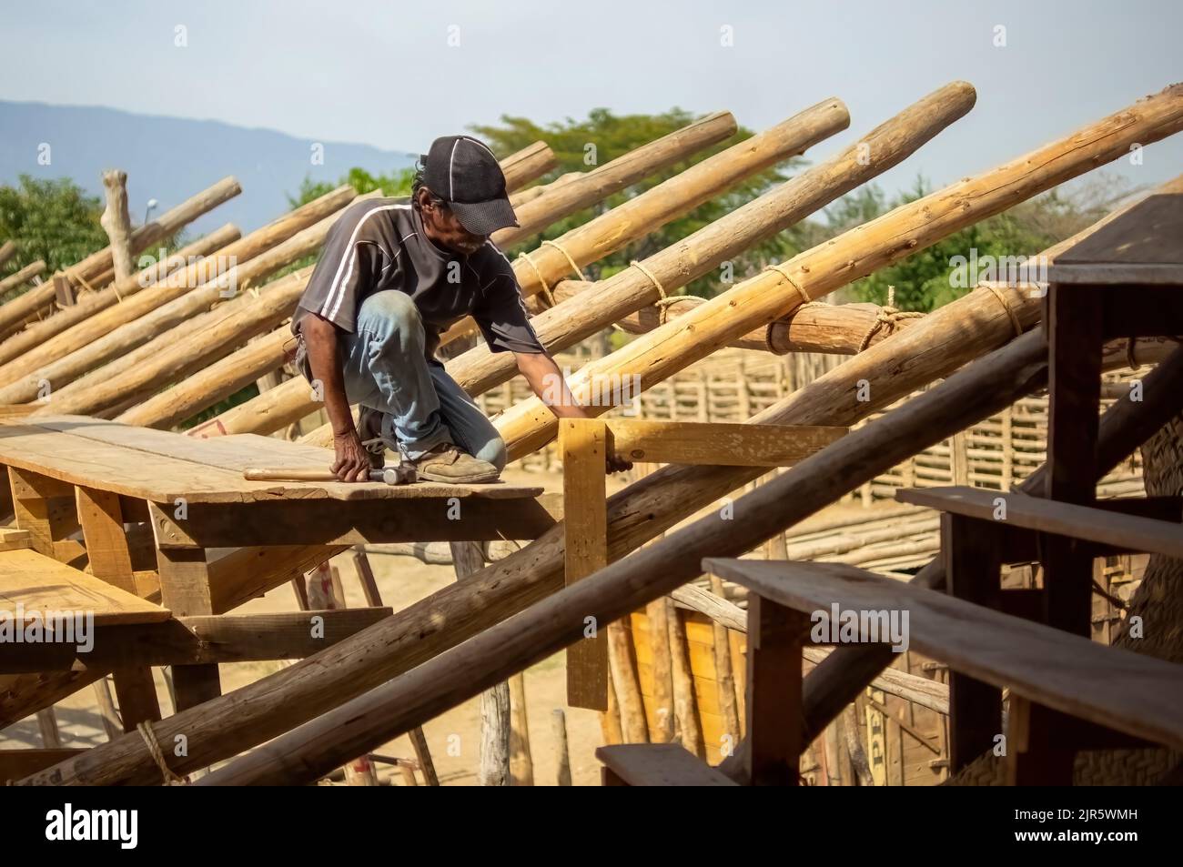 man making wooden roof, mason making roof formwork, with cap and hammer