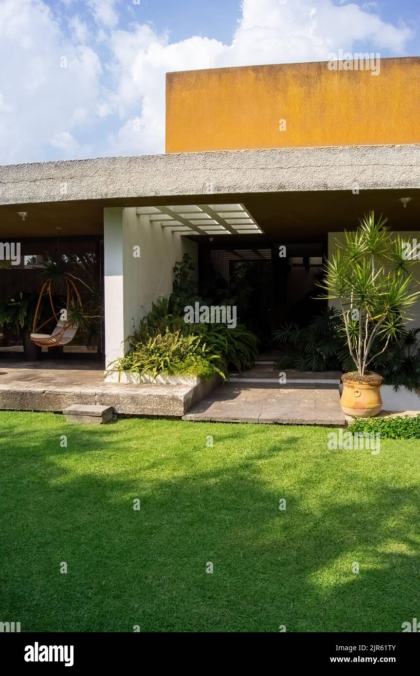 facade of a modern house with stone, staple that wraps the windows painted in gray, metal