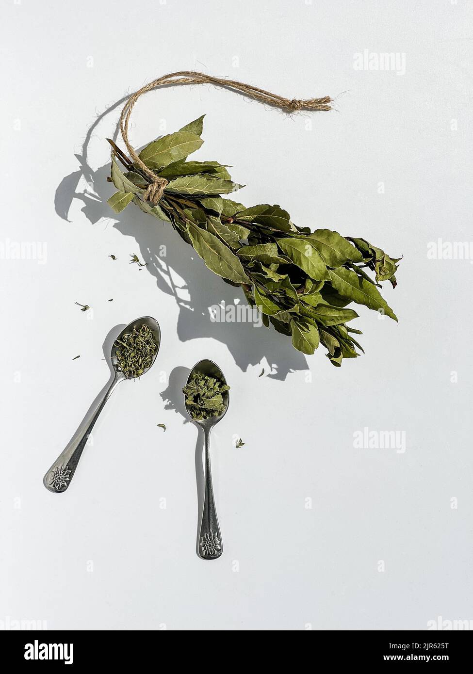 Dried bay leaves, thyme and mint on white background. Overhead shot