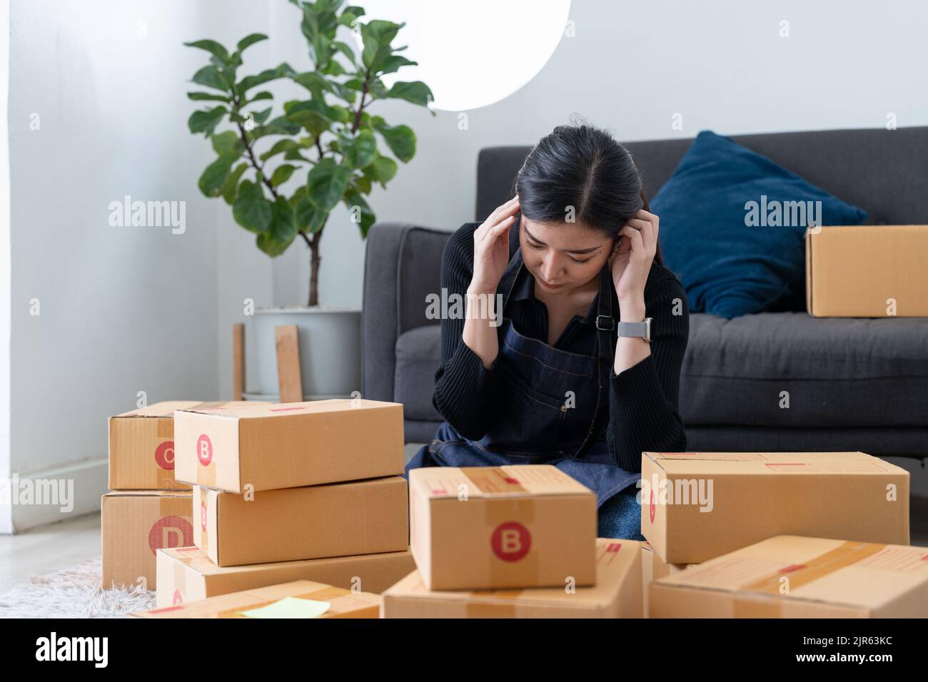 Young attractive asia female business owner thoughtful serious doubtful feel stress worry with financial problem in SME crisis small business Stock Photo