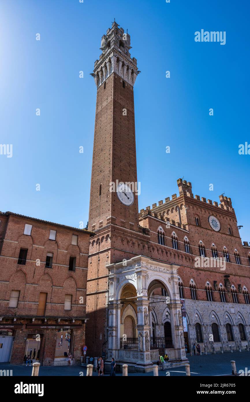 Torr del Mangia bell tower, with Palazzo Pubblico (Town Hall) on the right, in Piazza del Campo in Siena, Tuscany, Italy Stock Photo