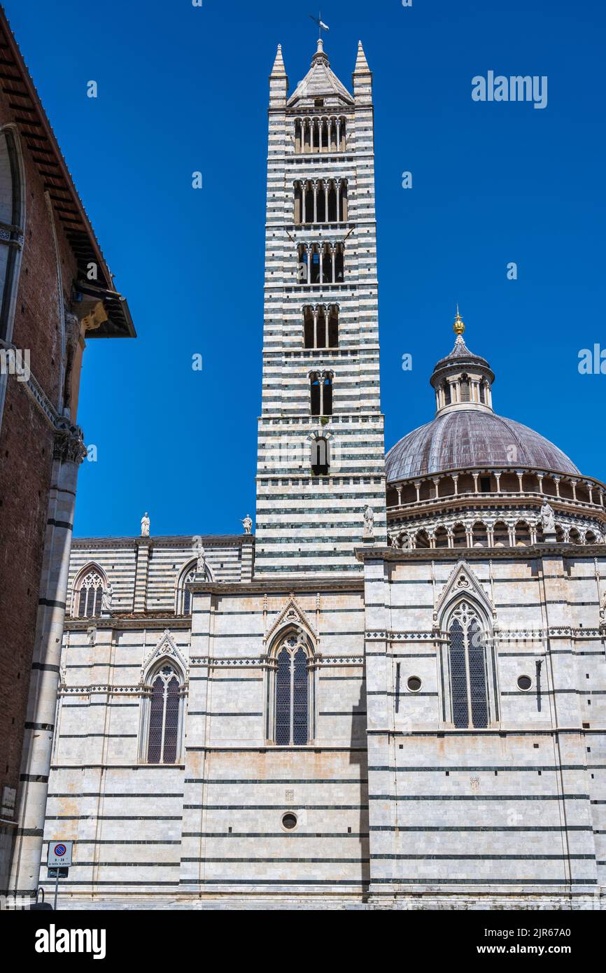 View of the Campanile (bell tower) and Dome of Siena Duomo (Siena Cathedral) from Piazza Jacopo della Quercia in Siena, Tuscany, Italy Stock Photo