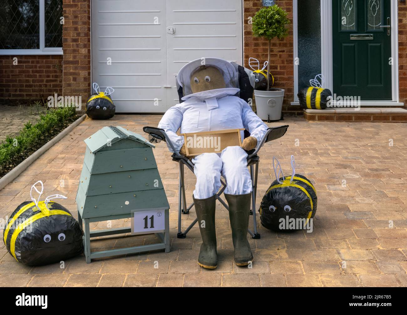 Flamstead Scarecrow Festival, Bee Keeper scarecrow and wooden beehive, Flamstead Hertfordshire Stock Photo