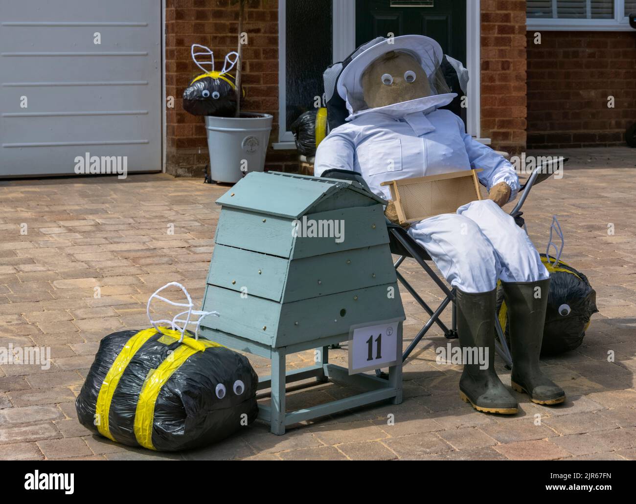 Flamstead Scarecrow Festival, Bee Keeper scarecrow and wooden beehive, Flamstead Hertfordshire Stock Photo