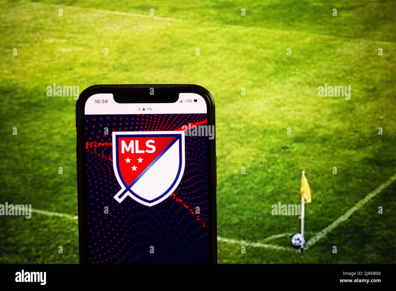 KONSKIE, POLAND - August 21, 2022: Smartphone displaying logo of MLS on soccer stadium background Stock Photo