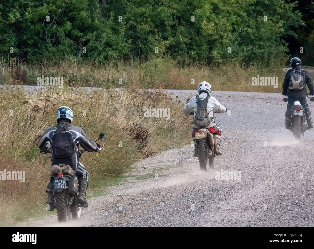 a group of three motor cyclists (bikers) riding their offroad