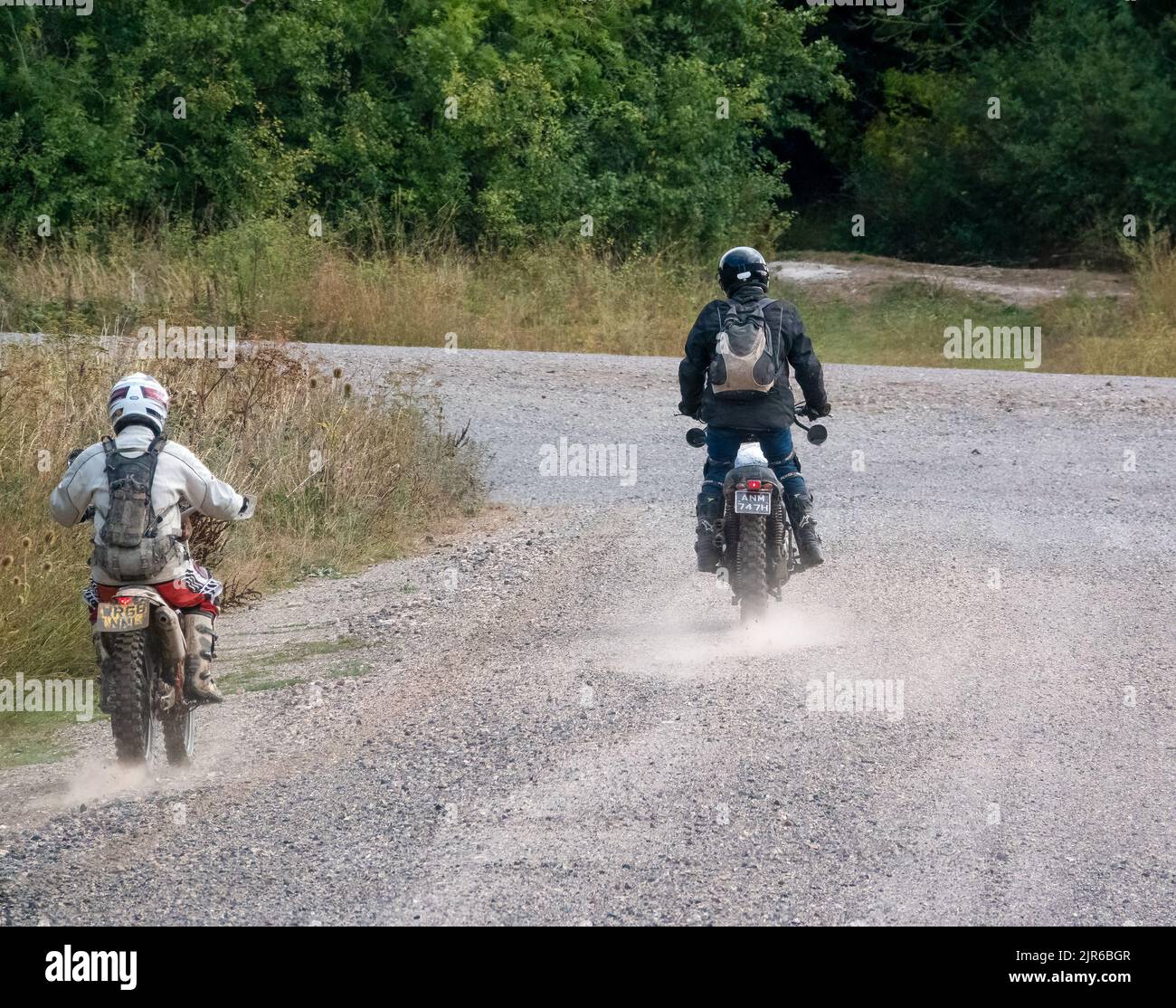 two motor cyclists (bikers) riding their offroad motorbikes along a
