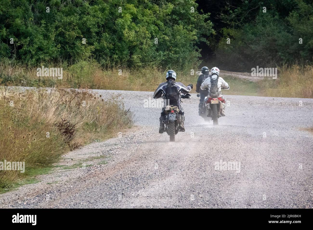 a group of three motor cyclists (bikers) riding their off-road ...