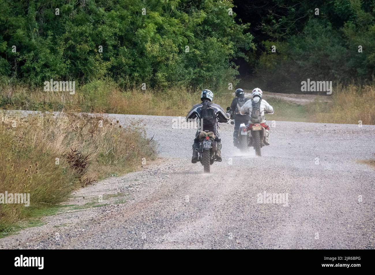 a group of three motor cyclists (bikers) riding their offroad
