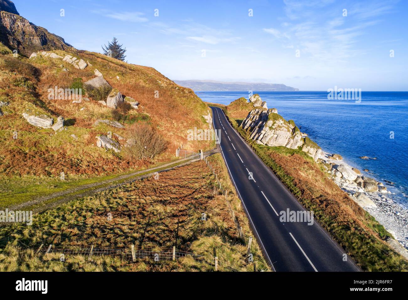 Causeway Coastal Route a.k.a Antrim Coast Road A2 on the Atlantic coast in Northern Ireland. One of the most scenic coastal roads in Europe. Aerial. Stock Photo