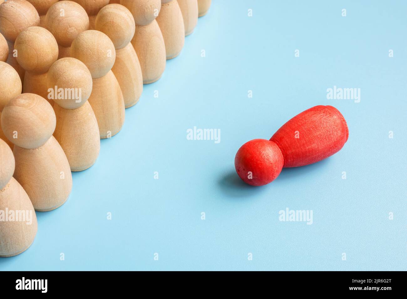 Social inclusion and equality abstract. A number of figurines and one red lies. Stock Photo