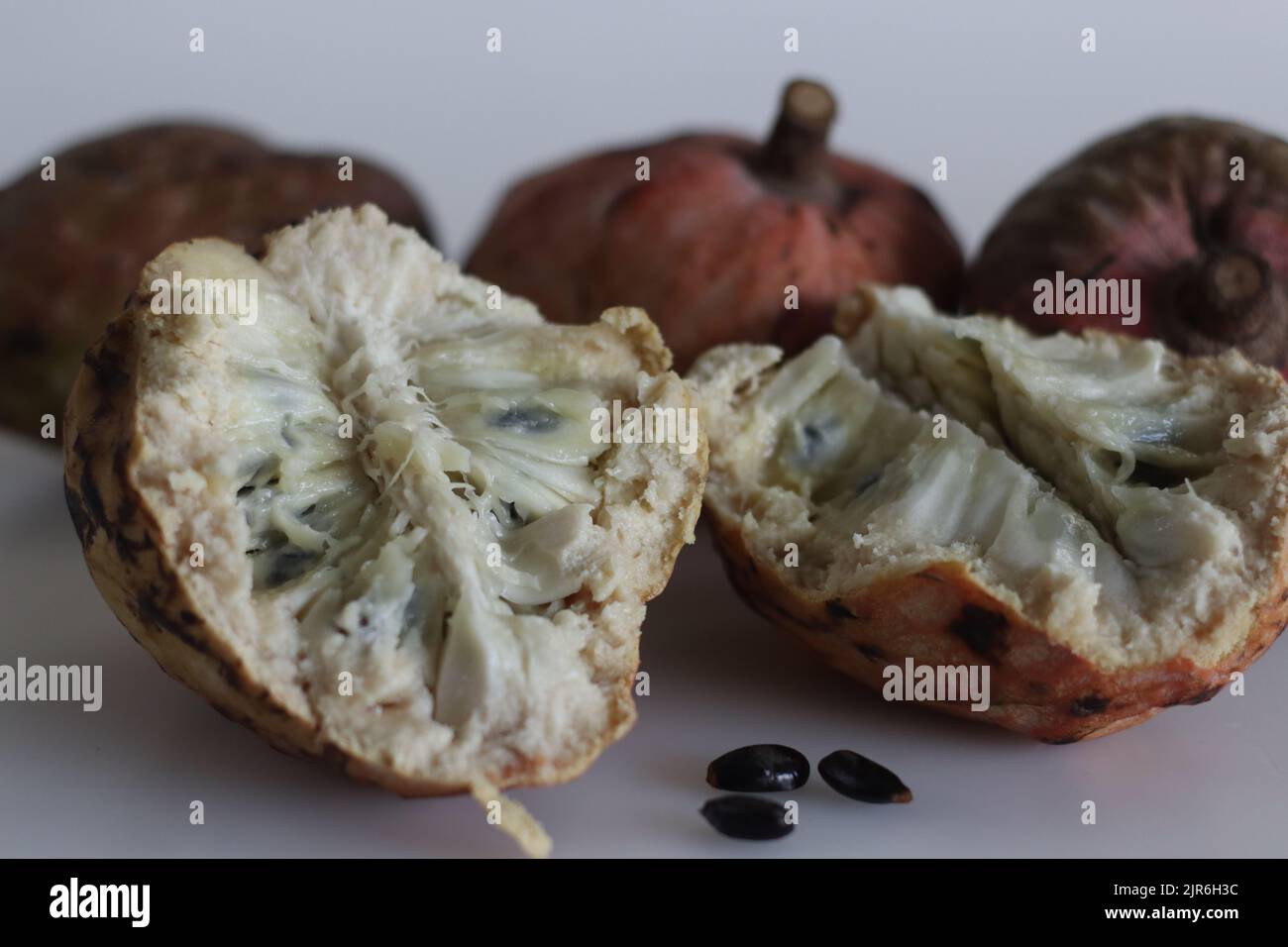 Slices of Red Custard Apple Fruit or Annona Reticulata Bullocks Heart. A fruit which is vary in shape. When ripe, fruit is brown or yellowish, with re Stock Photo