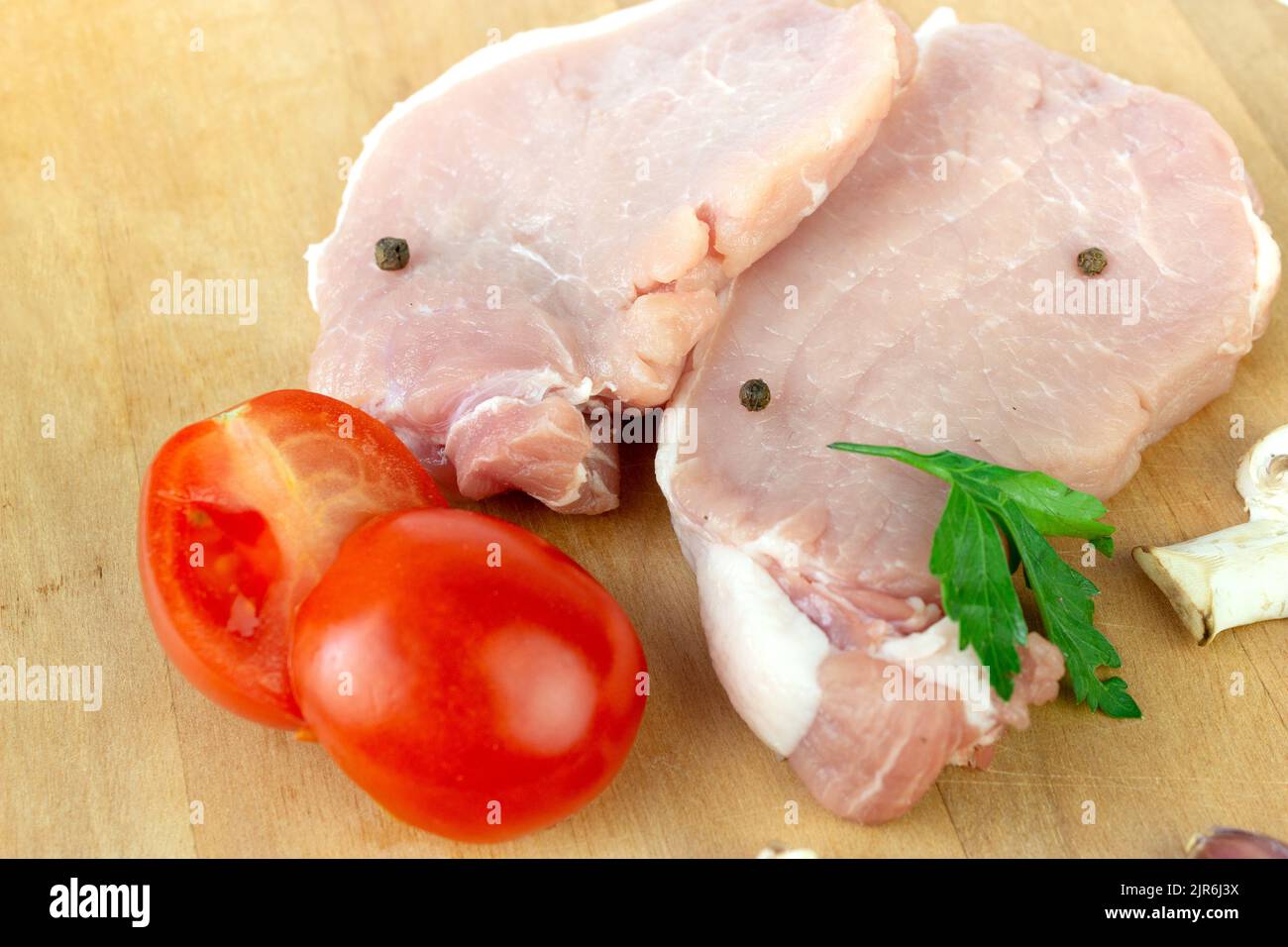 Raw meat. Raw fillet of stuck with garlic, tomato, spice, pepper, champignon close up Stock Photo