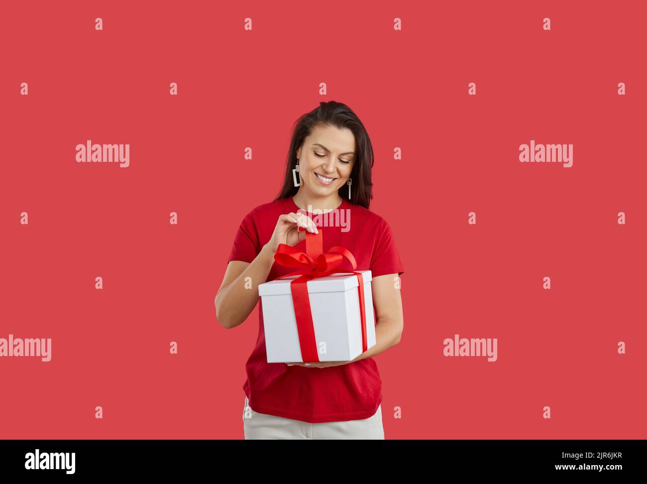 Happy woman open wrapped gift box with present Stock Photo
