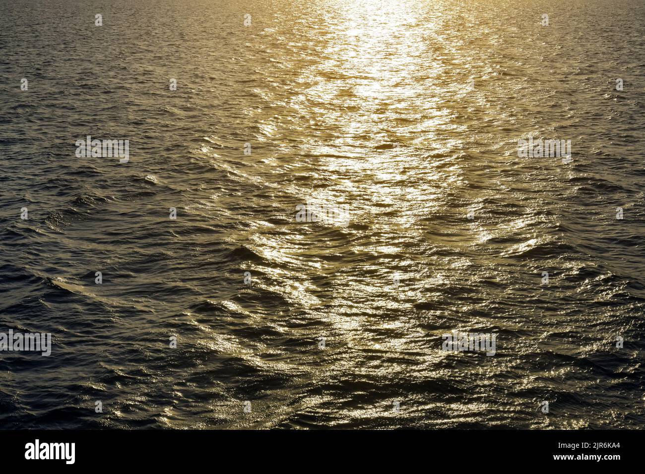 Solar glare of sea on surface at sunset. Golden sunset sun over sea. Magnificent seascape. Copy space. Selective focus. Stock Photo