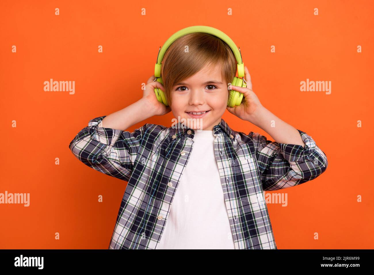 Photo of young little boy enjoy listen radio headphones meloman isolated over orange color background Stock Photo