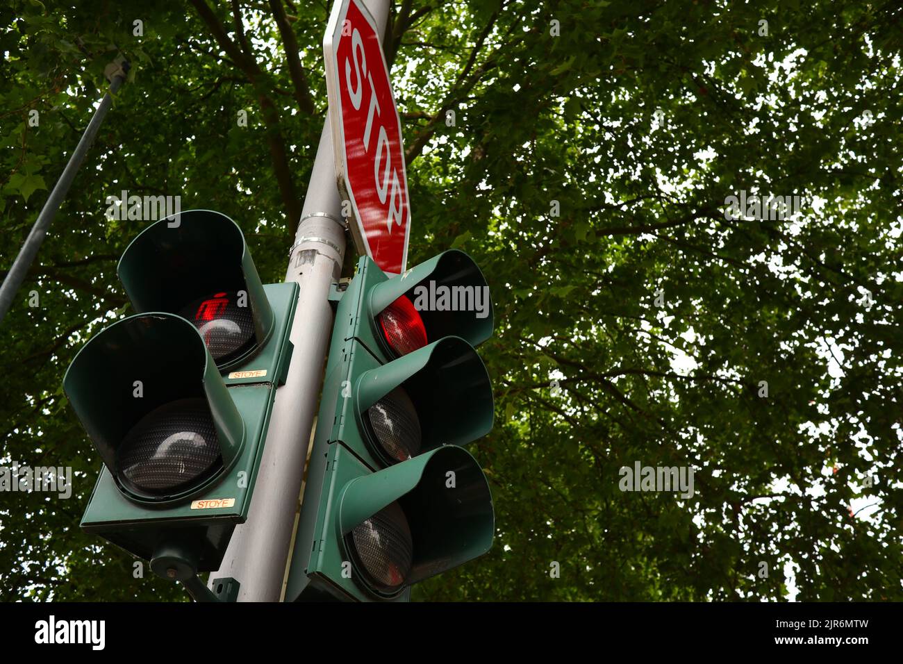 A stop traffic sign with traffic lights on red Stock Photo