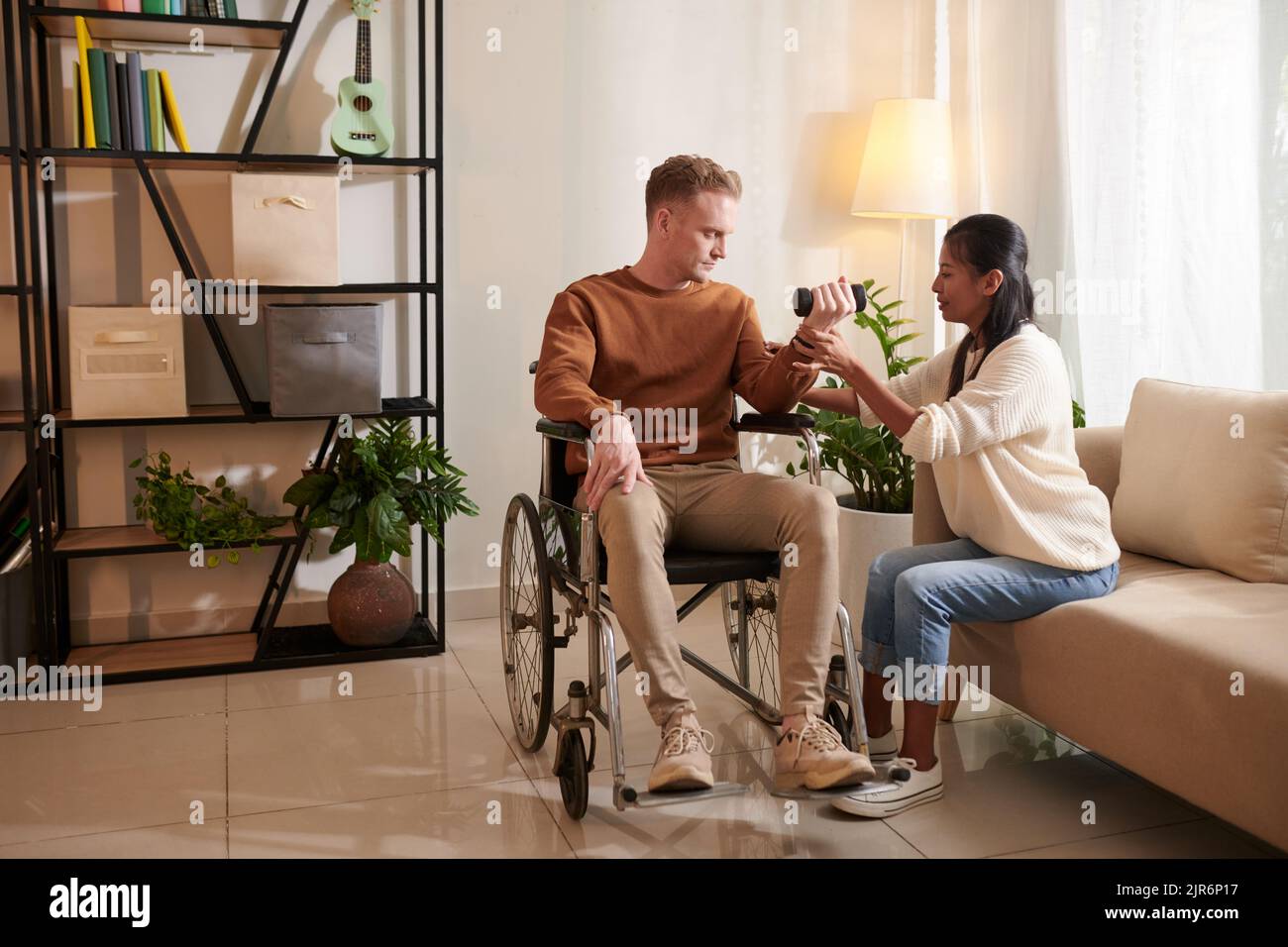 Caregiver explaining patient in wheelchair how to do exercise with