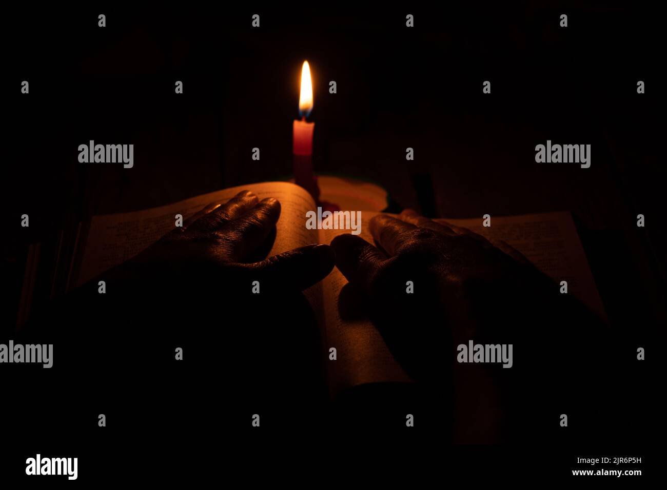 bible lies a candle flame of a candle in the dark, pray a bible, hands