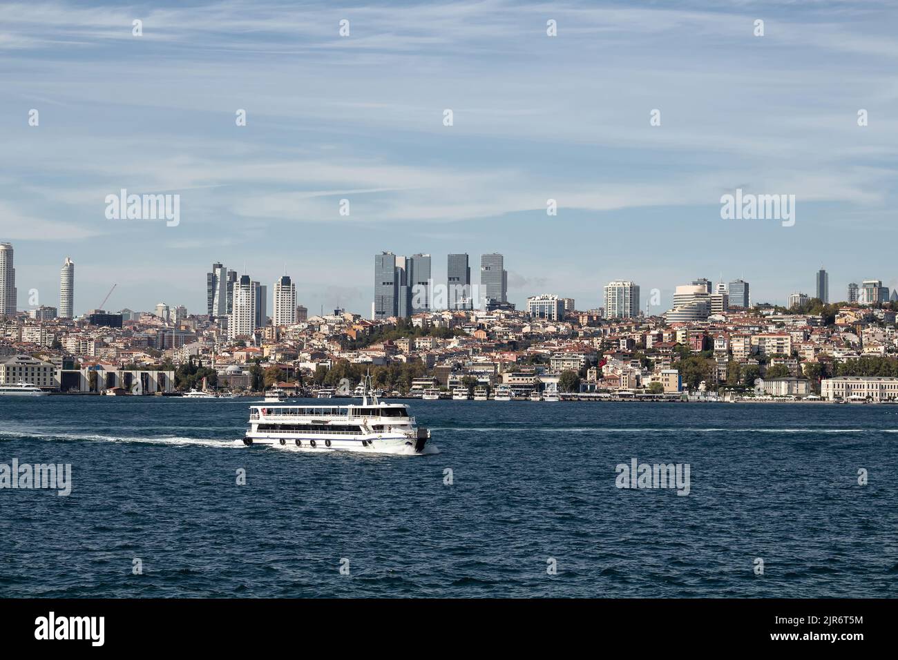 View of a cruise tour boat on Bosphorus and European side of Istanbul. It is a sunny summer day. Stock Photo