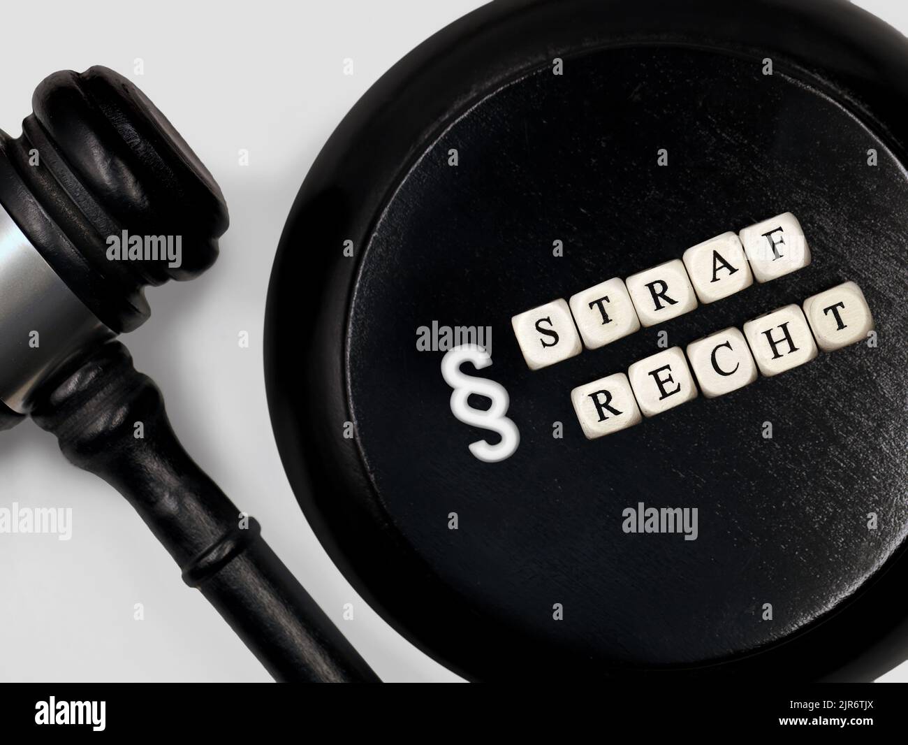 Judge gavel with round block and the german word Strafrecht for criminal law with paragraph symbol Stock Photo