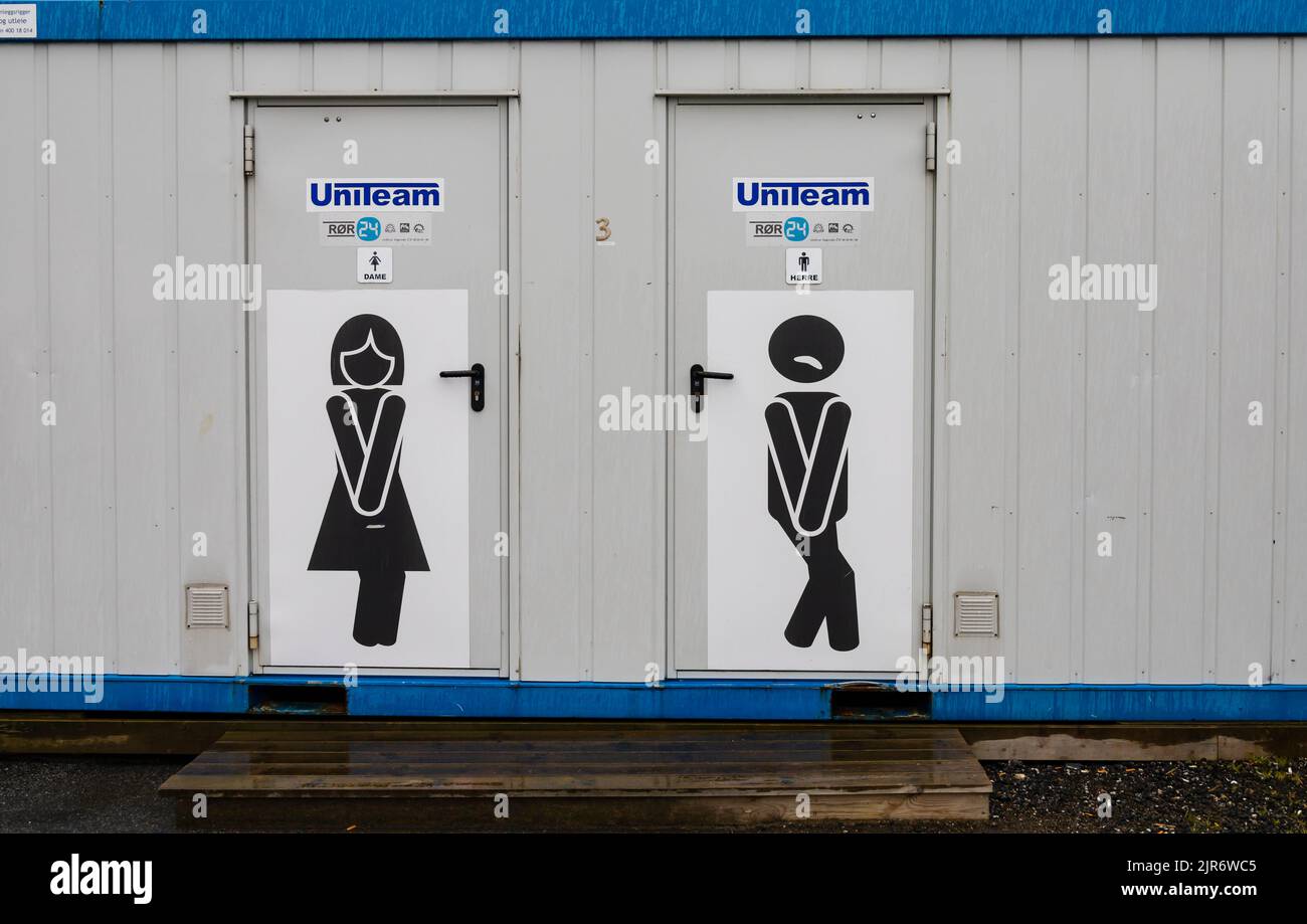 Container converted to public toilets with comic graphics on the doors. Alesund, Norway Stock Photo