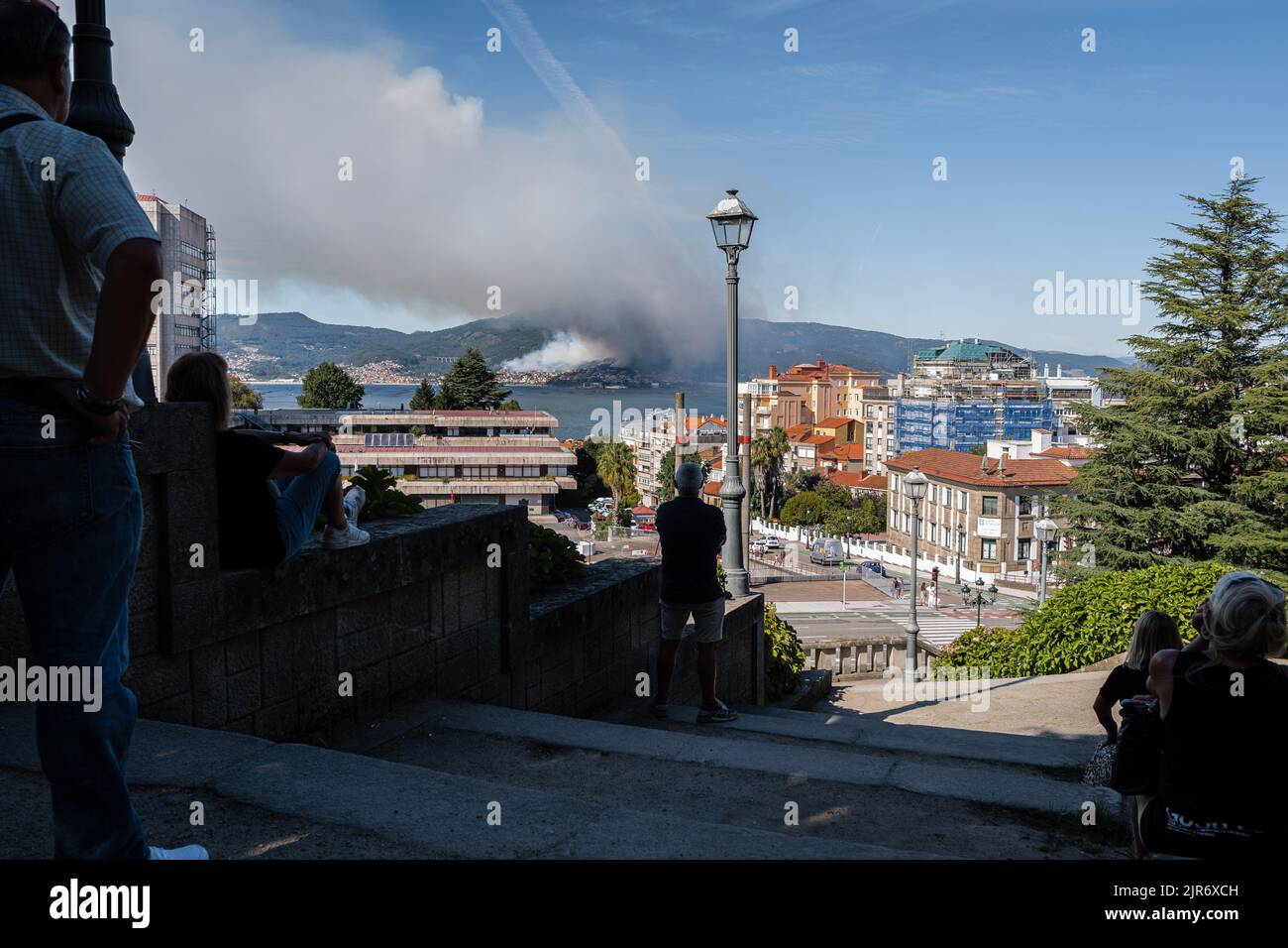 A group of people from the Vigo side looks towards the smoke from the