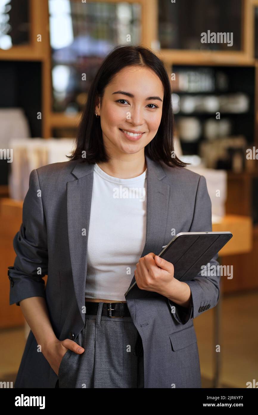 Young professional leader Asian business woman wearing suit, vertical portrait. Stock Photo