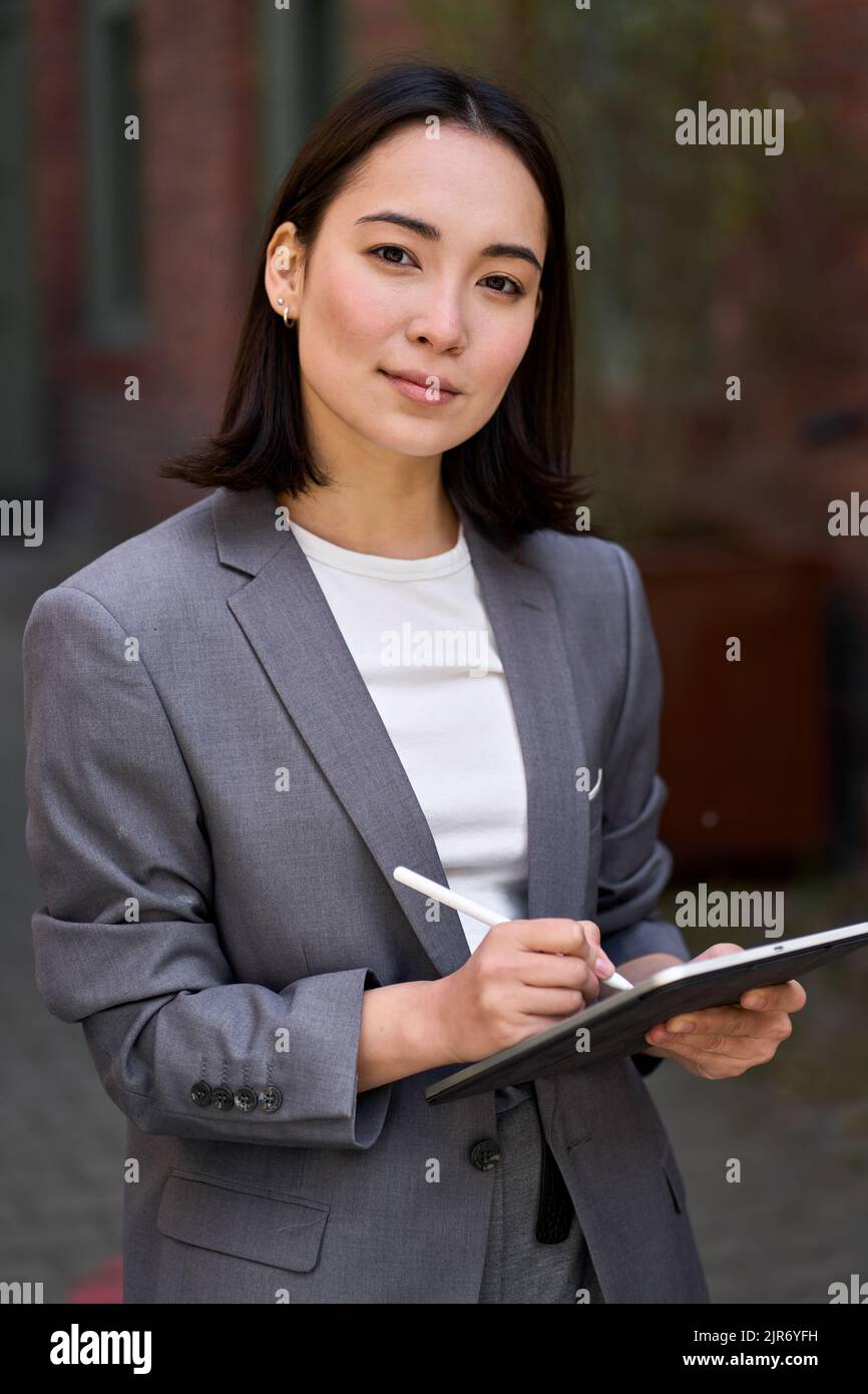 Young confident Asian business woman entrepreneur holding tablet, portrait. Stock Photo