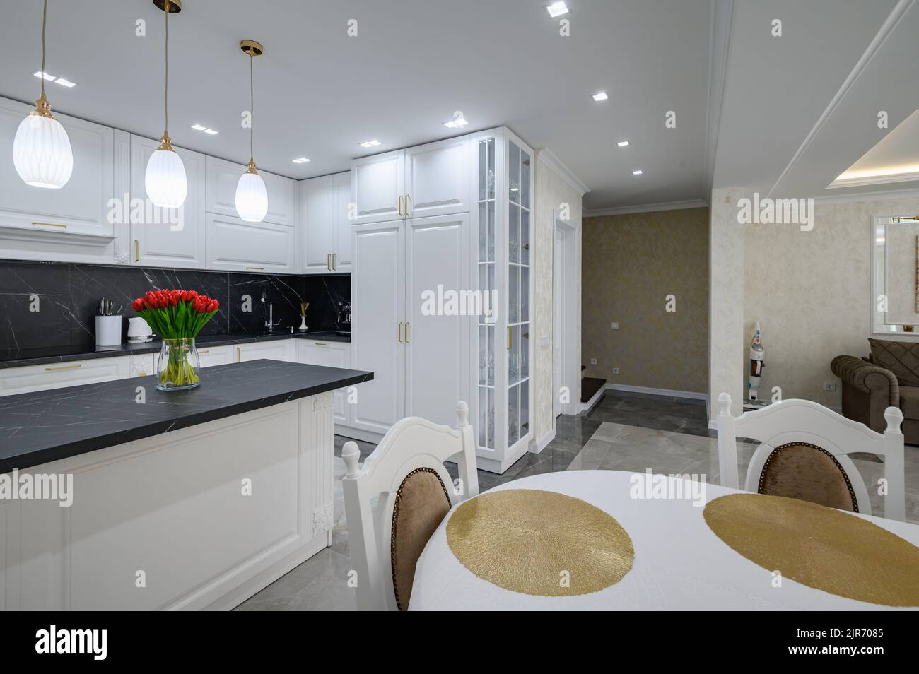 Luxurious white modern domestic kitchen with black marble worktop Stock Photo