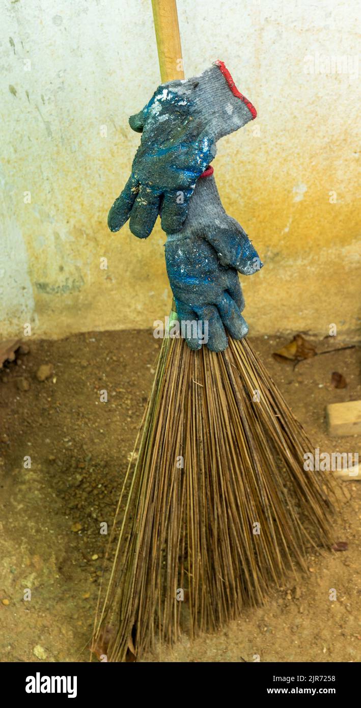 Gloves left unintentionally on a broom after work. Bad practice. Stock Photo