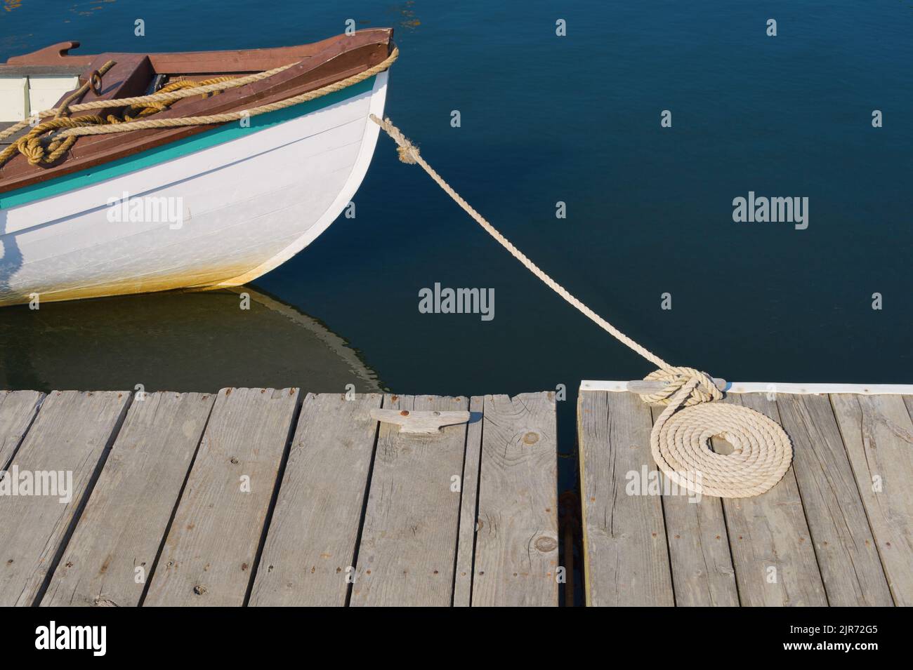 Wooden workboat docked and Flemish coil arrangement of docking line Stock Photo