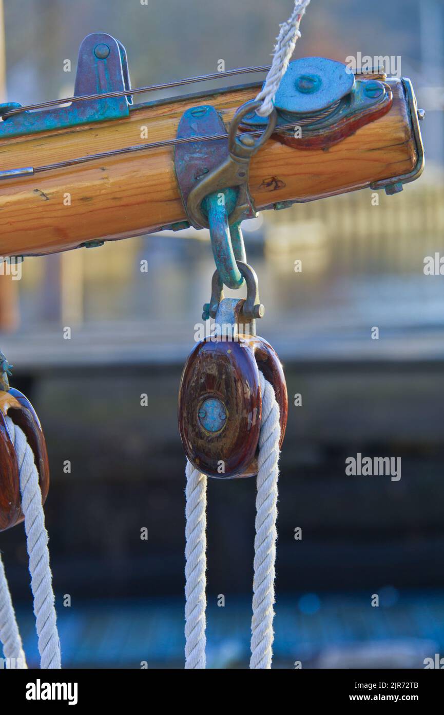Varnished wood pulley block on classic wood yacht medium long Stock