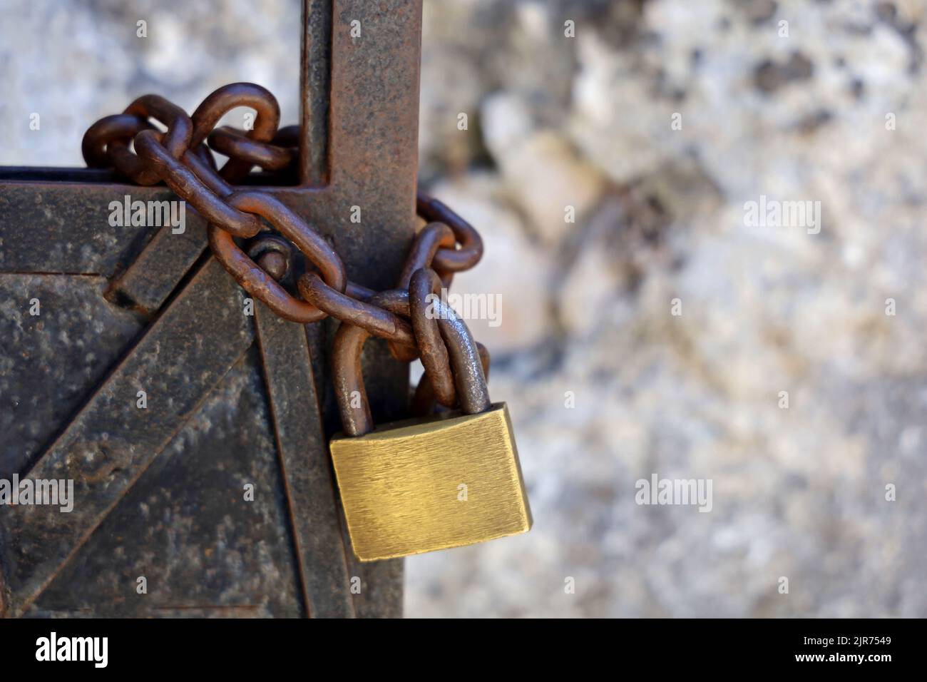 old rusty metal door with chain and brass padlock Stock Photo