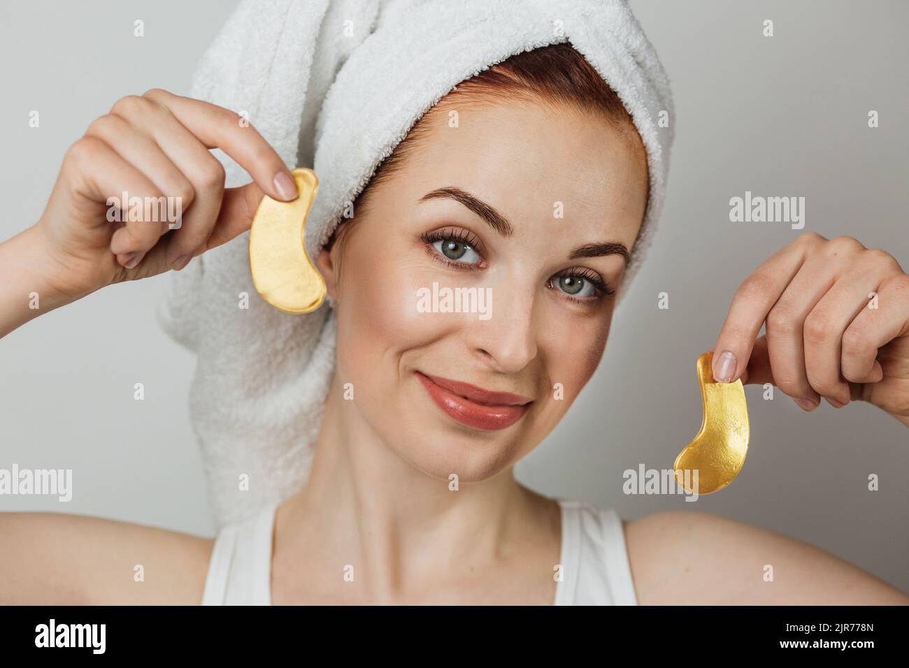 Portrait of pleasant caucasian young woman in towel with healthy skin ...