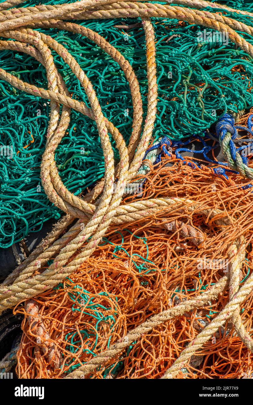 colourful abstract of fishing nets tackle and ropes and wires, abstract composition of nets in orange and green nylon, tangle of nets and wires ropes Stock Photo