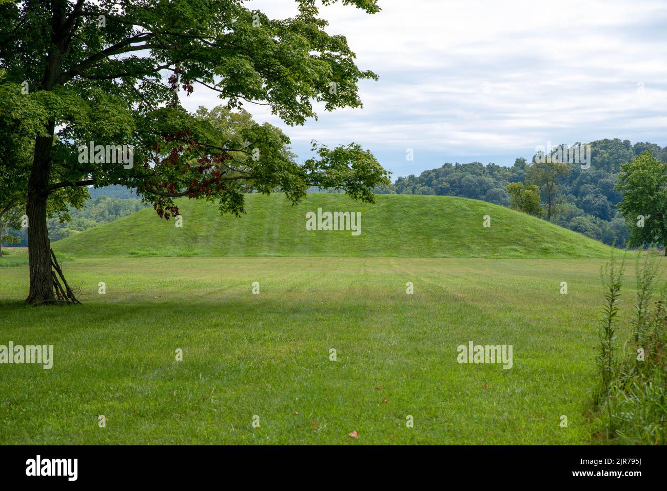 Large grass covered Native American prehistoric earthworks burial mound in Ohio Stock Photo