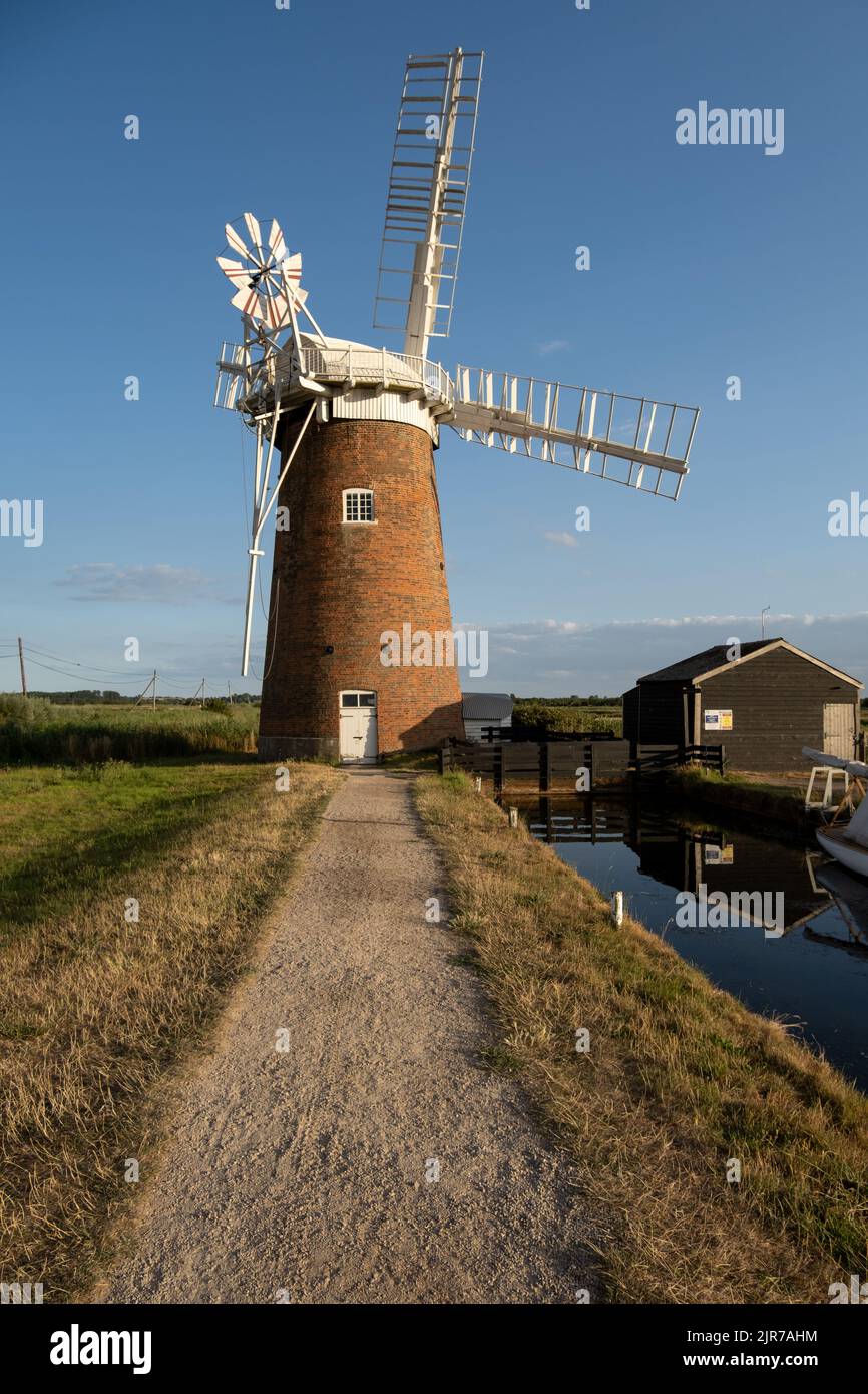 Perspective view along footpath towards Horsey Wind pump (windmill), an iconic Norfolk Broads landmark in England, UK. Stock Photo